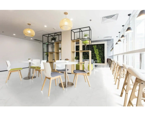 Lichte recreatieruimte met tafels, stoelen, planken en planten