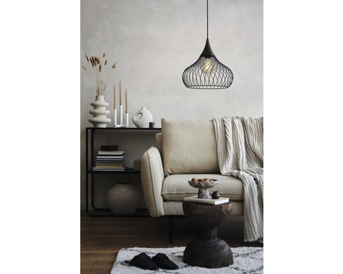 Woonkamer met bank, bijzettafel, plank en een zwarte draadhanglamp.