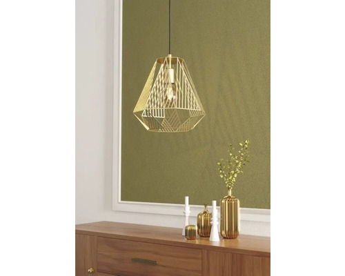 Gouden hanglamp boven een houten kast met decoratieve vazen en kandelaars