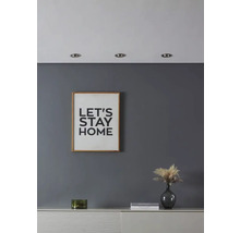 Woonkamer met afbeelding met tekst, decoratie en inbouwspots