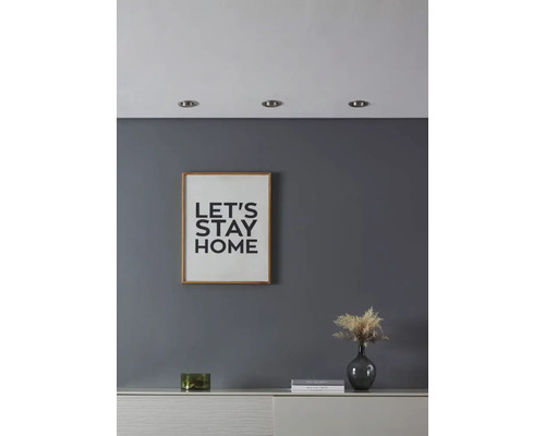 Woonkamer met afbeelding met tekst, decoratie en inbouwspots