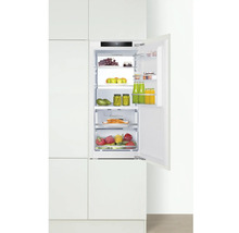 Geïntegreerde koelkast met open deur, gevuld met etenswaren in een keukenkast.