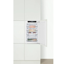 Ingebouwde vriezer met open deur in witte keuken