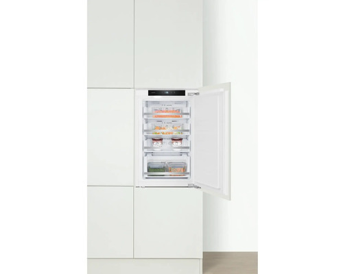 Ingebouwde vriezer met open deur in witte keuken
