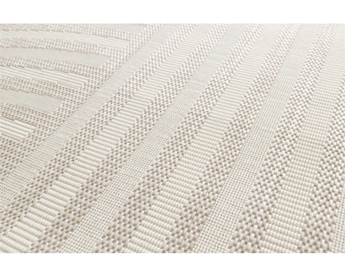 Detailopname van een lichtgekleurd tapijt met geometrisch patroon