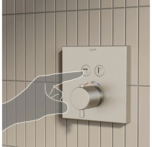 Wandgemonteerde douchekraan met hand die op de knop drukt