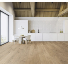 Lichte keukenruimte met houten vloer, eettafel en witte keukenkasten.