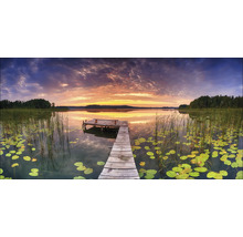 Houten steiger aan een meer met waterlelies bij zonsondergang