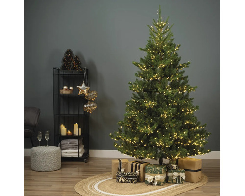 Versierde kerstboom met cadeaus en decoratie op een plank