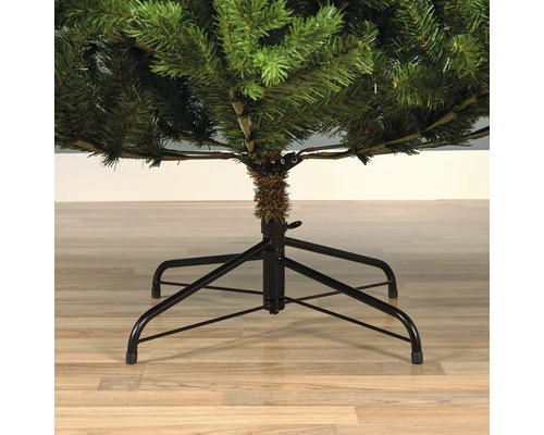 Gedetailleerde weergave van een kunstkerstboom met een zwarte metalen standaard