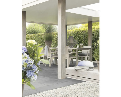 Overdekt terras met eettafel en tuinmeubelen.