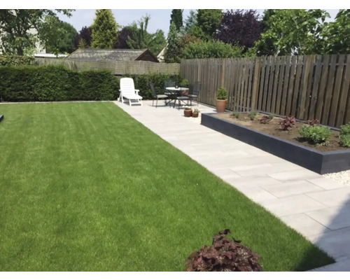 Tuin met gazon, stenen pad, verhoogde plantenbak en tuinafscheiding