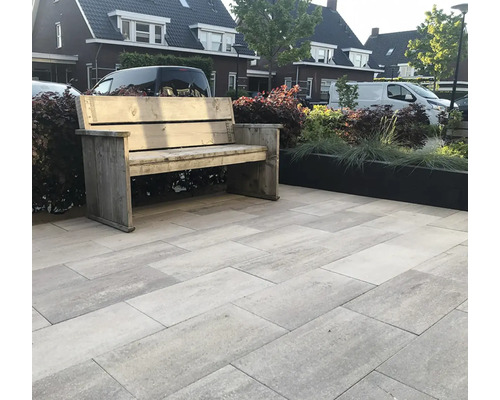 Tuin met houten bank en stenen vloerplaten.