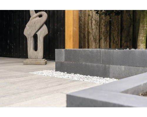 Decoratieve tuin met plantenbakken, grind en stenen beeld