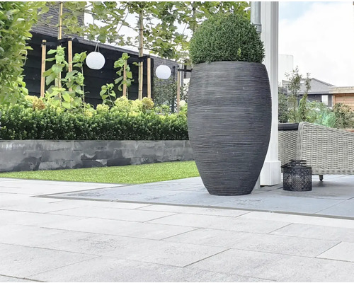 Tuin met bestrating, grote plantenbak en beplanting