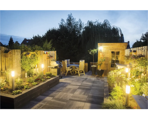 Tuinscene in de avond met terras, tuinhuis en verlichting