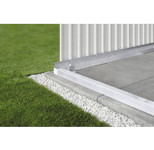 Detail van een aluminium funderingsframe op betonnen platen met grind en gazon.