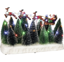 Decoratief kerstdorp met de kerstman in een slee, getrokken door rendieren, te midden van verlichte kerstbomen.