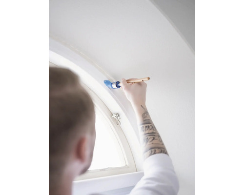 Iemand schildert een raamkozijn met een kwast.