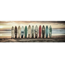 Meerdere surfplanken staan naast elkaar op het strand.