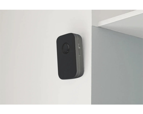 Zwarte bewegingsmelder aan een muur gemonteerd.