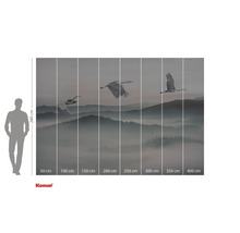 Fotobehang met kranen die over een bergachtig landschap vliegen