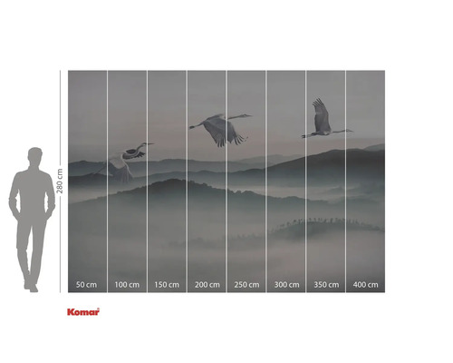 Fotobehang met kranen die over een bergachtig landschap vliegen