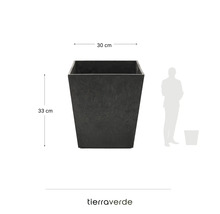 Vierkante Tierra Verde plantenbak in antraciet, 30 centimeter breed, 33 centimeter hoog, met schaalvergelijking met een persoon en Tierra Verde Logo.